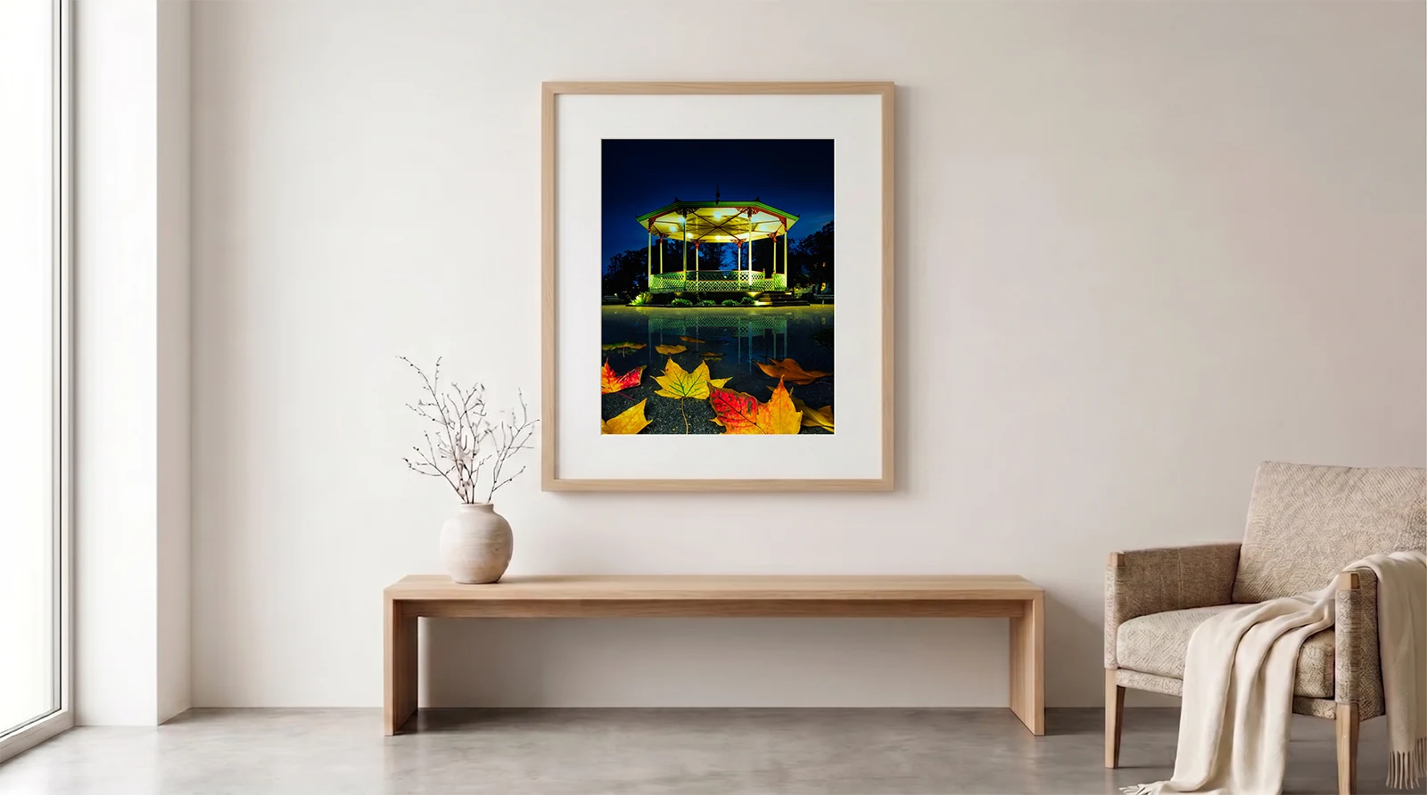 Minimalist room interior mockup featuring a framed art print of the illuminated Pump Room Gardens bandstand at night in Royal Leamington Spa.