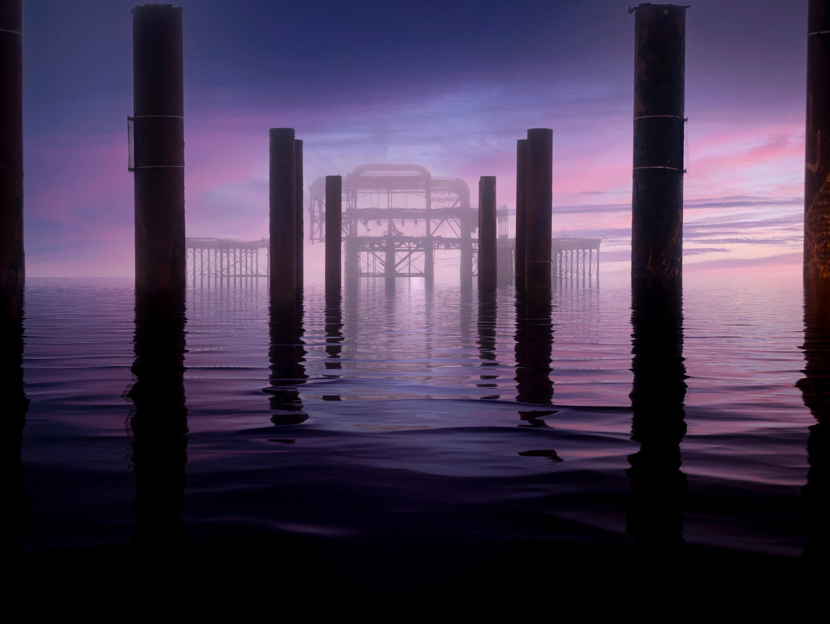 Serenity in the Amethyst Haze, a contemporary fine art photograph of Brighton's West Pier emerging through a soft purple morning mist, reflected in calm tidal water.